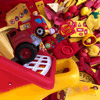 Rainbow Squared, Year 5, Piece Twenty-Nine: 3. Red Yellow. A pile of red and yellow toys shrinks as one piece disappears one by one, and then loops by reappearing. This includes toy trucks, books, blocks, food, etc.